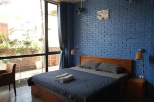 a bedroom with a bed with a blue brick wall at Kiara's Home - Quiet Garden Villa in Hai Phong