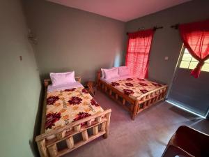 a bedroom with two beds and a window at Oltare Safari Homestay in Makuyuni +8 photos
