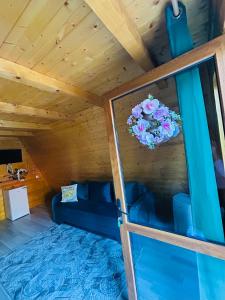 a living room with a blue couch and a wreath on a ceiling at Casa Ursu in Cârțișoara