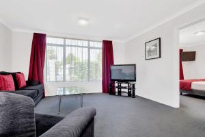 a living room with a couch and a television at Matamata Central Motel in Matamata