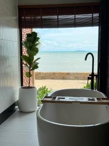 a bath tub in a room with a view of the ocean at Boon Heritage House Koh Samui in Koh Samui +55 photos