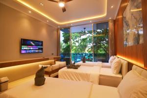 a hotel room with two beds and a tv at Lighthouse Hotel in Gili Trawangan
