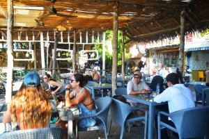 a group of people sitting at tables in a restaurant at Lighthouse Hotel in Gili Trawangan