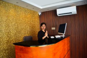a woman standing behind a desk with a computer at Lighthouse Hotel in Gili Trawangan +60 photos