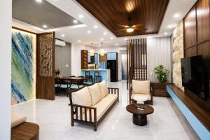 a living room with a couch and a table at Modern 3BR Villa , Poolside, 4min Shuttle to Beach in Bình Tú