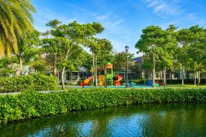 a playground in a park next to a river at Modern 3BR Villa , Poolside, 4min Shuttle to Beach in Bình Tú