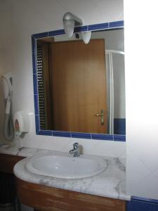 een badkamer met een wastafel en een spiegel bij Hotel Parco in Castellammare di Stabia