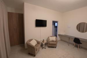 a living room with two chairs and a table at Weavers Nest Guesthouse in Modimolle