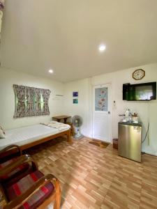 a living room with a couch and a tv on the wall at Baan Suan Yensabai @Ayutthaya in Phra Nakhon Si Ayutthaya
