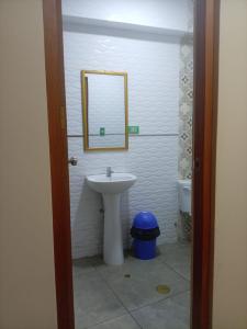 a bathroom with a sink and a mirror and a toilet at Perú Andina Tours & Hostel Amparo in Huaraz