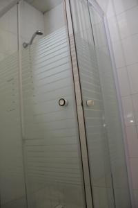 a shower stall with a glass door at Residencial Bela Star in Porto