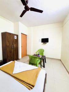 a bedroom with a bed and a table and a tv at Hotel Laxmi in Hinjewadi