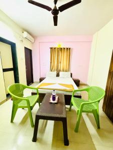 a bedroom with a bed and two chairs and a table at Hotel Laxmi in Hinjewadi