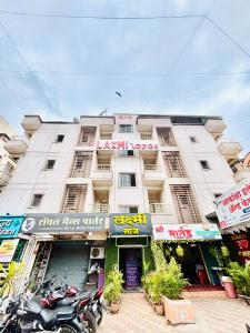 a white building with a motorcycle parked in front of it at Hotel Laxmi in Hinjewadi
