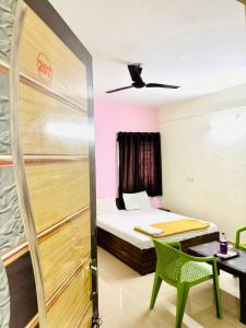 a room with a bed and a table and a desk at Hotel Laxmi in Hinjewadi