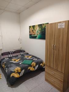 a bedroom with a bed and a wooden cabinet at KALIFORNIA CENTRAL in Alicante