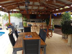 - patio z drewnianym stołem i krzesłami w obiekcie Ocean Reef Homestay w mieście Perth