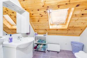 a bathroom with a white sink and a wooden ceiling at Rustic Cottage With Heated Pool - Happy Rentals in Velika Buna +19 photos