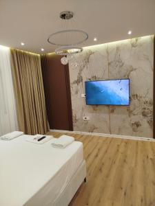 a room with two beds and a flat screen tv on a wall at Boci studio apartments in Ulcinj