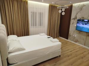 a bedroom with a bed and a flat screen tv at Boci studio apartments in Ulcinj
