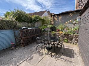a patio with a table and chairs in a garden at 3 Lowerbourne Terrace in Minehead
