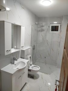 a white bathroom with a sink and a toilet at Boci studio apartments in Ulcinj +32 photos