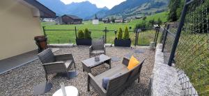 a patio with chairs and a table and a fence at Bijou Hollandia in Engelberg +22 photos