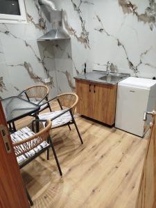 a kitchen with a sink and two chairs and a refrigerator at Boci studio apartments in Ulcinj