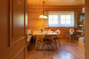 a dining room with a table and chairs in a cabin at Haus Obweg - Postalm in Abtenau