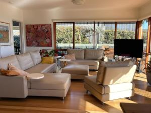 a living room with couches and a flat screen tv at Lorne Beach House in Lorne