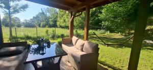 a patio with a couch and a table and a hammock at Bliżej Lasu - Rodzinny domek w górach in Stary Gieraltów