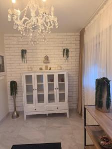 a room with a white cabinet and a chandelier at Haus EL MILO in Jadranovo