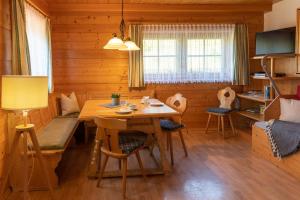 a dining room with a table and chairs in a cabin at Haus Obweg - Postalm in Abtenau
