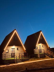 a couple of buildings with lights on them at Ðedovina mountain cabins in Žabljak