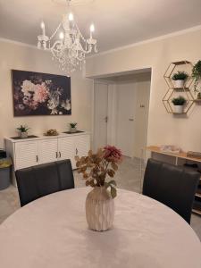 a dining room with a table with a vase with flowers at Haus EL MILO in Jadranovo