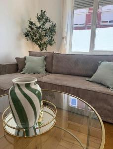 a vase sitting on a glass table in front of a couch at La bulle dunkerquoise in Coudekerque-Branche