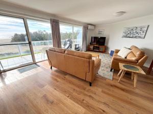 a living room with a couch and a chair at Ocean Shores Apartment 14 - Bring your own linen. in South West Rocks