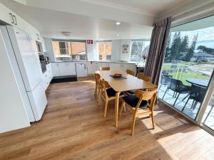 a kitchen and dining room with a table and chairs at Ocean Shores Apartment 14 - Bring your own linen. in South West Rocks