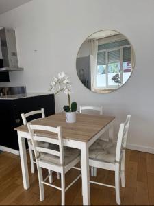 a dining room table and chairs with a mirror at La bulle dunkerquoise in Coudekerque-Branche