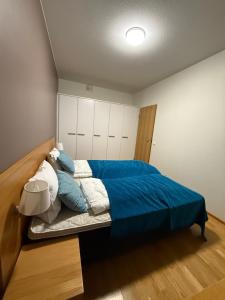 a bedroom with a bed with blue sheets and pillows at Ruka Chalets Royal Apartments in Ruka