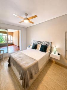 a bedroom with a large bed with a ceiling fan at Bungalow with Pool & BBQ - Carabassi Beach 10' in Gran Alacant +18 photos