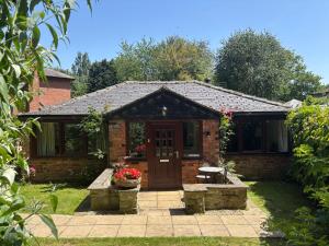 a small brick house with a red door at Claire Cottage in Selby