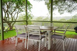 a wooden table and four chairs on a porch at Sanctuary by Sirromet in Mount Cotton
