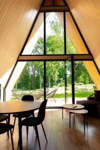 a room with tables and chairs and a large window at Frame Village in Žaugėdai