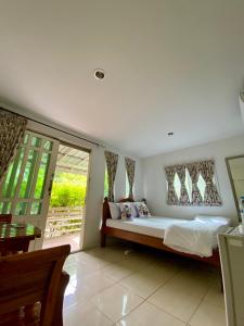 a bedroom with a bed and a large window at Baan Suan Yensabai @Ayutthaya in Phra Nakhon Si Ayutthaya