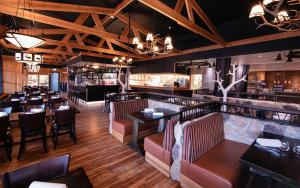 a restaurant with tables and chairs and a bar at Ruka Chalets Royal Apartments in Ruka
