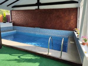 a swimming pool with two faucets in a house at Pensiunea Casa Nina in Cârțișoara