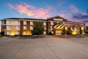 a hotel building with a tree in front of it at AmericInn by Wyndham Fairfield in Fairfield