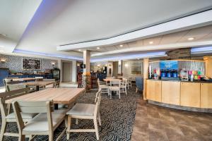 a restaurant with tables and chairs and a bar at AmericInn by Wyndham Fairfield in Fairfield