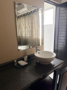 a bathroom with a sink and a mirror on a counter at Hotel Peccato Originale in Tuxtla Gutiérrez